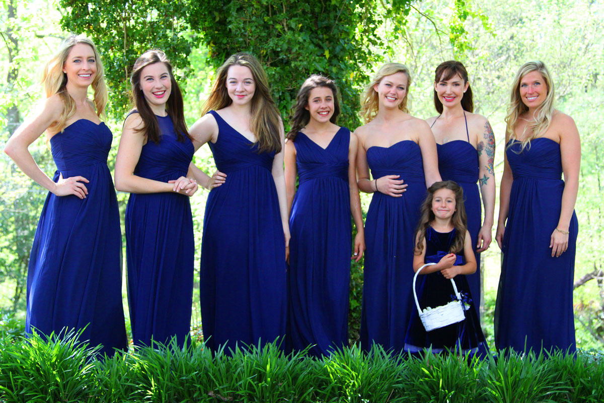 Bridesmaids lined up wearing blue dresses.